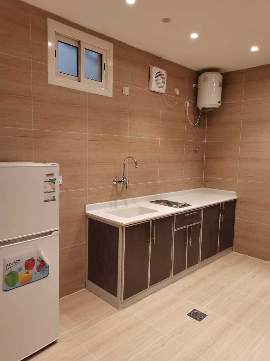 Cuina petita amb nevera, rentapelats i finestra.
