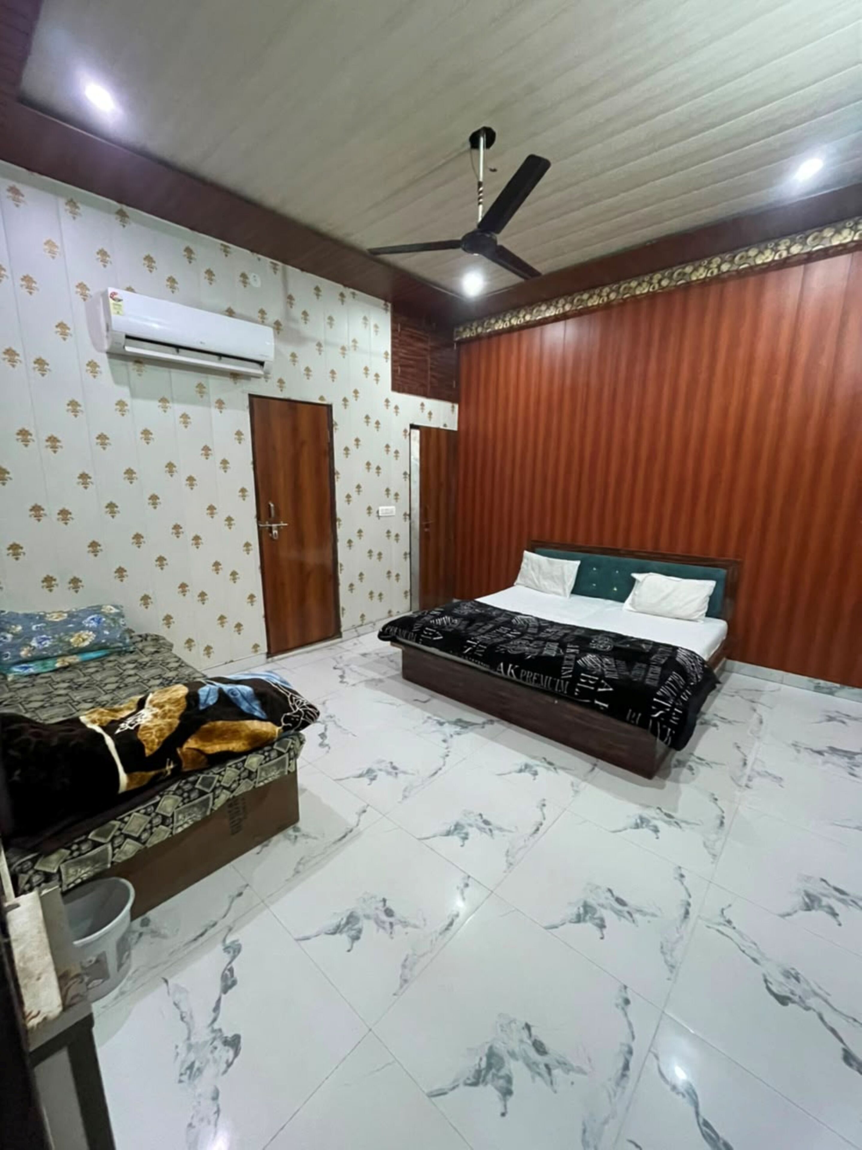 A bedroom with a bed, a bedside table, a wardrobe, and an air conditioning unit.