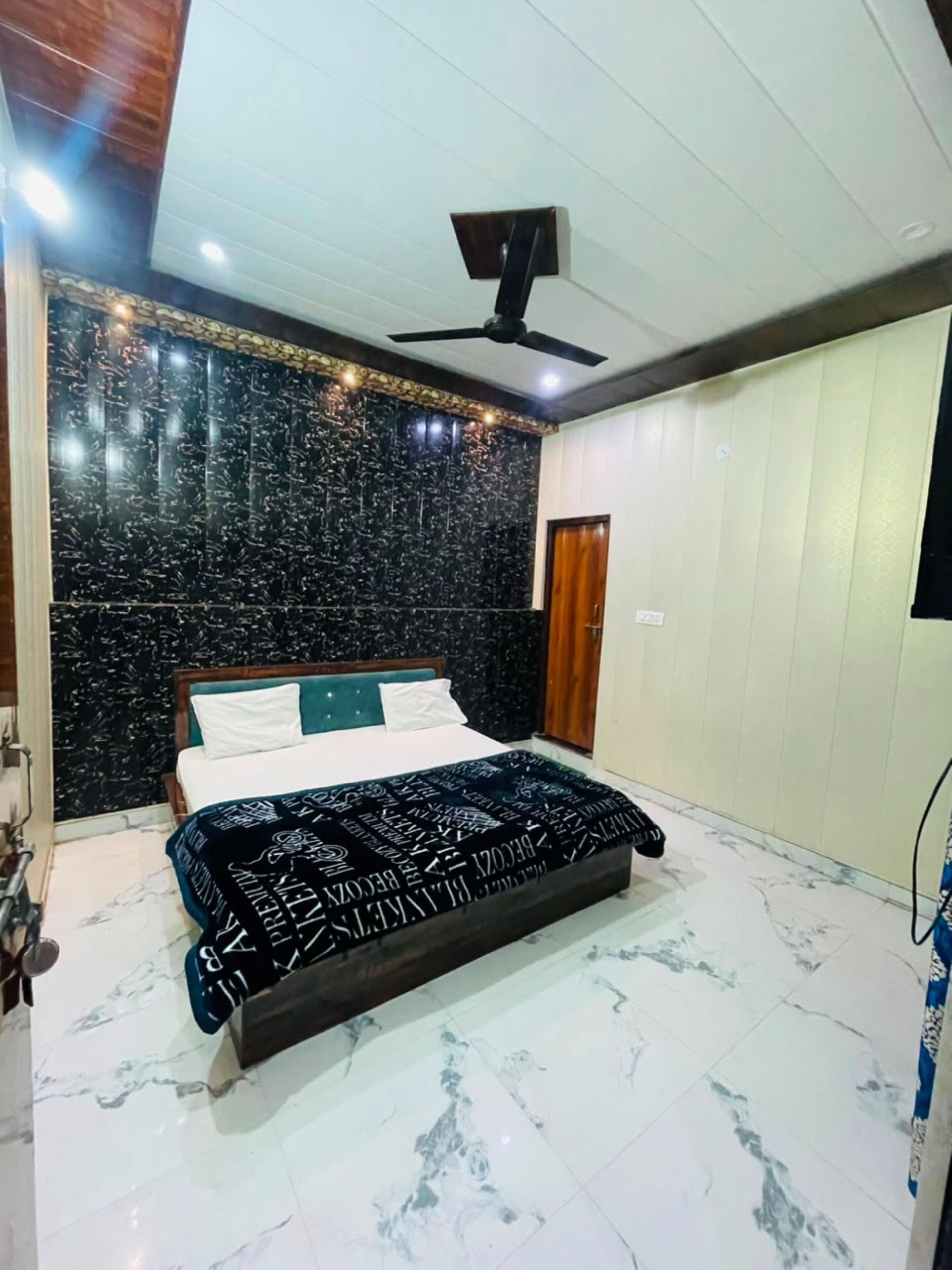 A bedroom with a bed, a ceiling fan, and a marble floor.