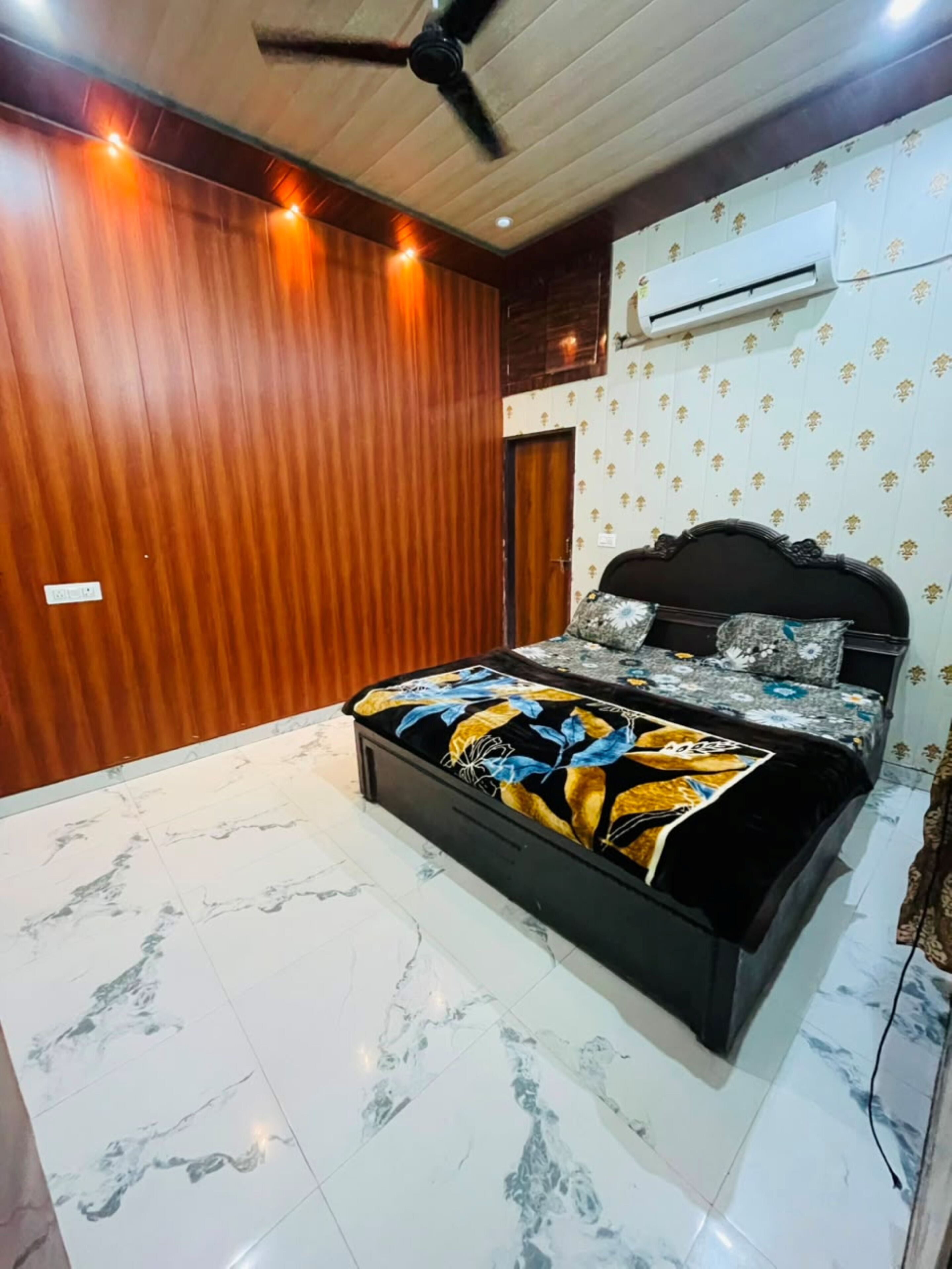 Une chambre à coucher avec un lit, des murs en bois, un climatiseur et un ventilateur de plafond.