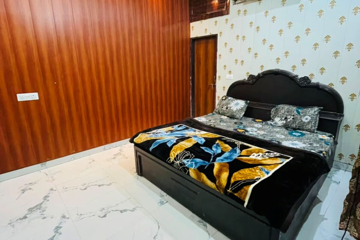 A bedroom with a bed, wooden walls, an air conditioning unit, and a ceiling fan.