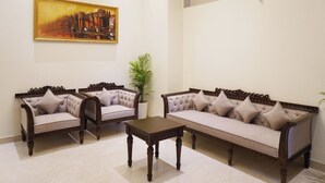 Una habitación con dos sofás tapizados, una mesa de centro de madera y un cuadro enmarcado en la pared.