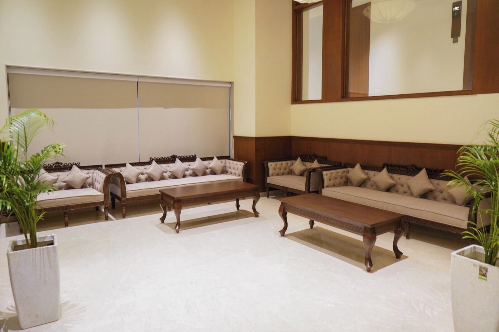 Un salón de conferencias con una pizarra grande, varios sofás y mesas de madera.
