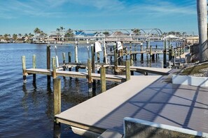 A waterfront dock with wooden posts and a concrete walkway. - CCVS - Dream Villa Mango Bay (Cape Coral)
