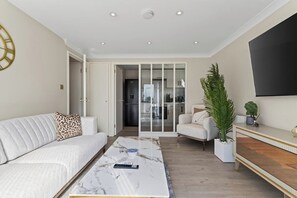 Ein modernes Wohnzimmer mit einer Couch, einem Couchtisch und einem Fernseher.