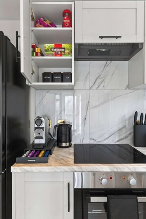Eine moderne Küche mit integrierter Kaffeemaschine, Wasserkocher und Kaffeemühle auf der Arbeitsfläche.