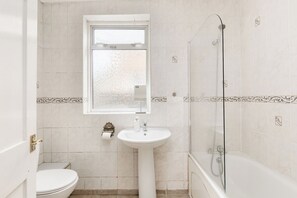 A small bathroom with a toilet, a sink, and a shower. - New! Charming 1BR Maisonette | Alexandra Park (Greater London)