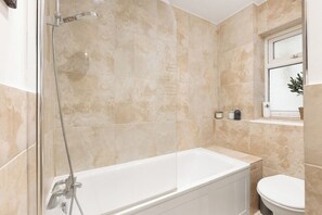 A bathroom with a bathtub, a shower, and a toilet. - New! West Kensington 2BR Gem w/Garden & Patio (Greater London)