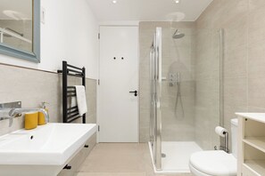 Ein modernes Badezimmer mit Dusche, Toilette und Waschbecken.