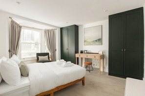 Ein Schlafzimmer mit Bett, Schreibtisch, Stuhl und Kleiderschrank.