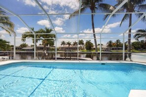 Ein Swimmingpool mit Blick auf Palmen und einen klaren Himmel.