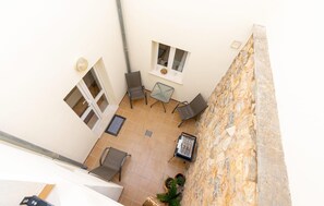 A courtyard with a table and chairs, a small window, and a stone wall. - Awesome apartment in Arta with WiFi (Arta)