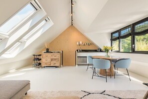 Une chambre de style loft moderne, dotée d’une lucarne, d’un plafond en pente en bois et d’une grande fenêtre.