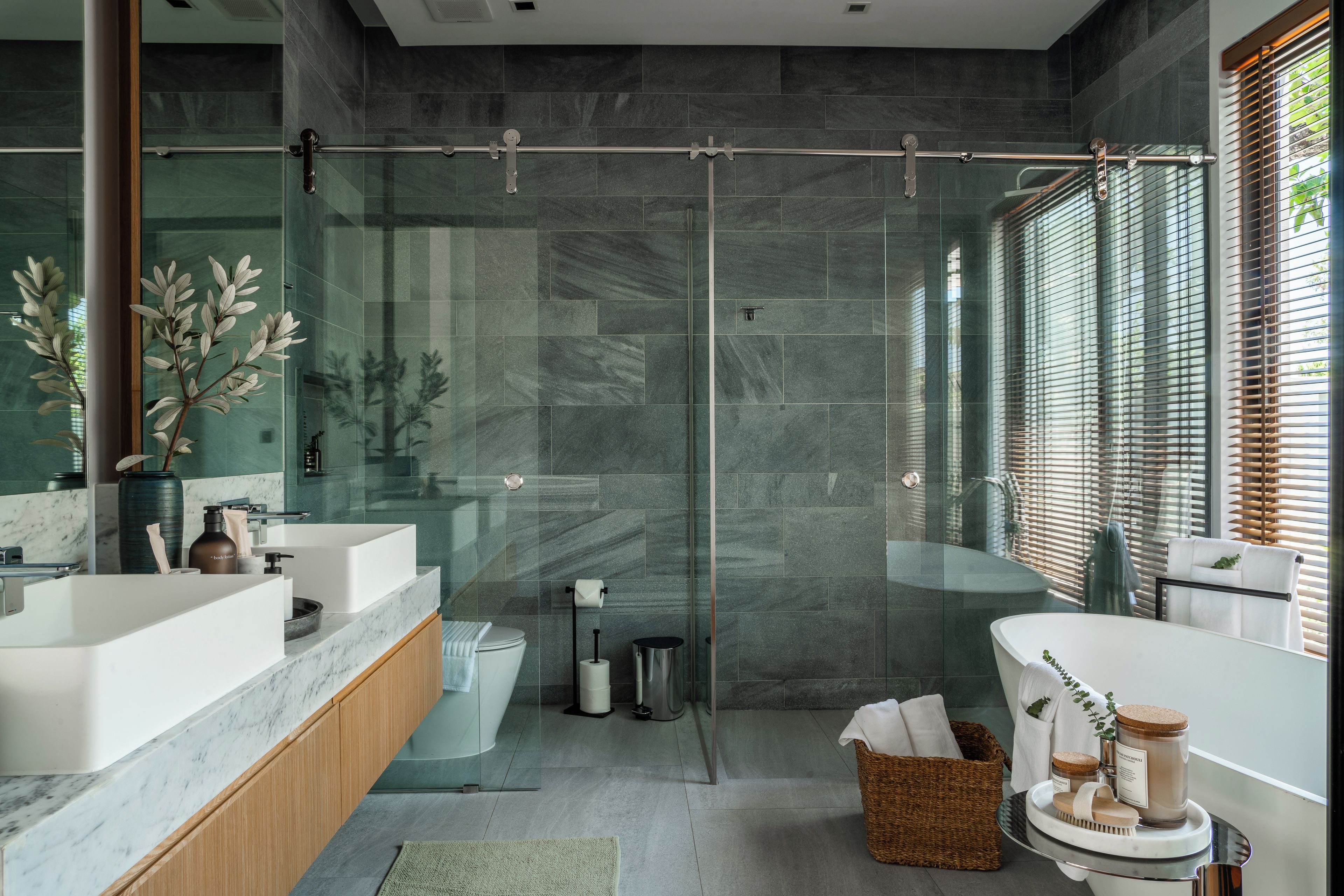 Une salle de bain moderne avec une douche à parois de verre, une baignoire blanche et un meuble-lavabo doté d’un plan de travail en marbre.