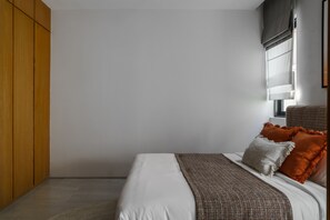 A bedroom with a bed, pillows, a window with blinds, and a wooden wardrobe. - Layan - Private Designer Villa (Tambon Thep Krasatti)