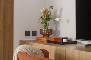 A wooden desk with a vase of flowers, a book titled 'LOUIS VUITTON CATWALK,' and a candle. - Layan - Private Designer Villa (Tambon Thep Krasatti)