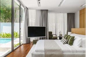 Une chambre moderne avec un grand lit, un téléviseur à écran plat et une vue sur une piscine.
