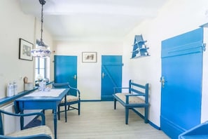 A room with a dining table, chairs, and a blue door.