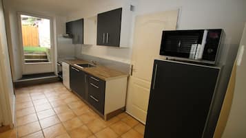 A compact kitchen with a microwave, a refrigerator, and a sink.