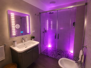 A modern bathroom with a vanity, mirror, and shower. - M.a.g.a. Holiday House in Taormina – Studio with Parking, Sea View, and Self Check-in (Taormina)