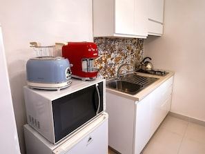 A compact kitchen with a microwave, toaster, and coffee maker on a countertop. - M.a.g.a. Holiday House in Taormina – Studio with Parking, Sea View, and Self Check-in (Taormina)