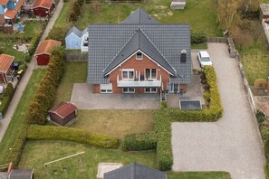 A residential house with a sloped roof, a front porch, and a driveway. - Holiday apartment with 1 bedroom (Fehmarn)