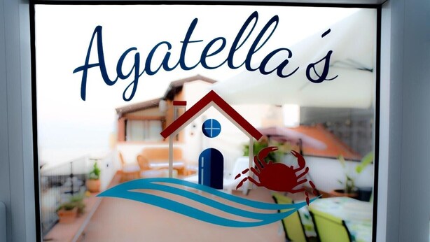 Logotipo com uma casa e um caranguejo, e o texto 'Agatella's HOUSE'.