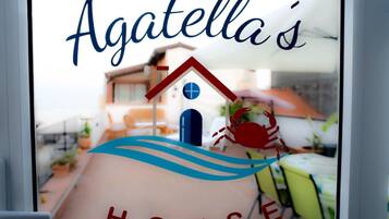 En logotyp med ett hus och en krabba, samt texten ”Agatellas HUS”.