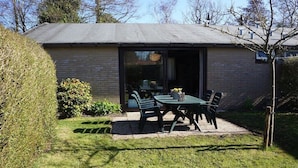 Une maison avec un patio, une table et des chaises.