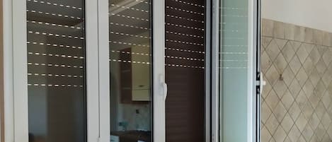 A room with a window, a radiator, and a tiled wall.