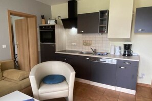 A compact kitchen with a built-in oven, a dishwasher, and a coffee maker. - holiday home at the harbor (Zingst)