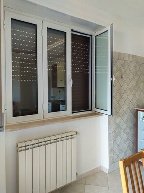 A room with a window, a radiator, and a tiled wall. - A Peace Of Rome (Lazio)