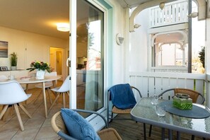 A balcony with a glass table, chairs, and a potted plant. - Anchorage - Binz Stars (Ostseebad Binz)
