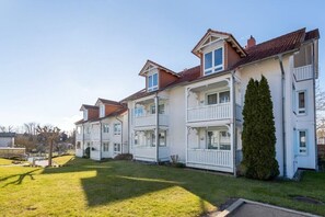 A row of white two-story houses with balconies, a well-maintained lawn, and a clear sky. - Anchorage - Binz Stars (Ostseebad Binz)