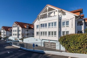 A white building with balconies, labeled 'APARTHOTEL BINZER STERNE,' with a clear blue sky in the background. - Anchorage - Binz Stars (Ostseebad Binz)