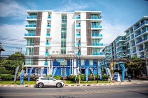 Een hotel met meerdere verdiepingen, modern vormgegeven, met balkons en een overdekte ingang.
