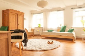 A room with a bed, a chair, a small table, a cabinet, and a round rug. - Holiday apartment with 5 bedrooms (Strachau)