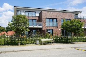 A modern building with a brick facade, large windows, and a balcony. - Holiday apartment in Boizenburg with sauna (Boizenburg)