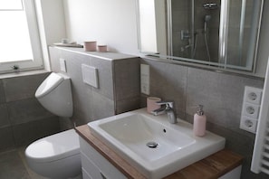 A bathroom with a toilet, sink, and shower. - Holiday apartment in Boizenburg with sauna (Boizenburg)