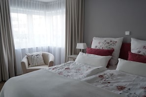 A hotel room with a bed, a chair, and a nightstand with a lamp. - Holiday apartment in Boizenburg with sauna (Boizenburg)