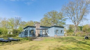A two-story house with a patio area, a chimney, and a lawn. - Holiday home with 2 bedrooms (Burgh-Haamstede)