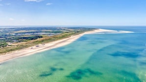 An aerial view of a coastal area with a beach and clear waters. - Holiday home with 2 bedrooms (Burgh-Haamstede)