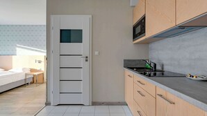 Eine kleine Küche mit Mikrowelle, Herd und Holzschränken.