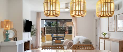 A dining area with a wooden table, wicker chairs, and a view through a glass door.