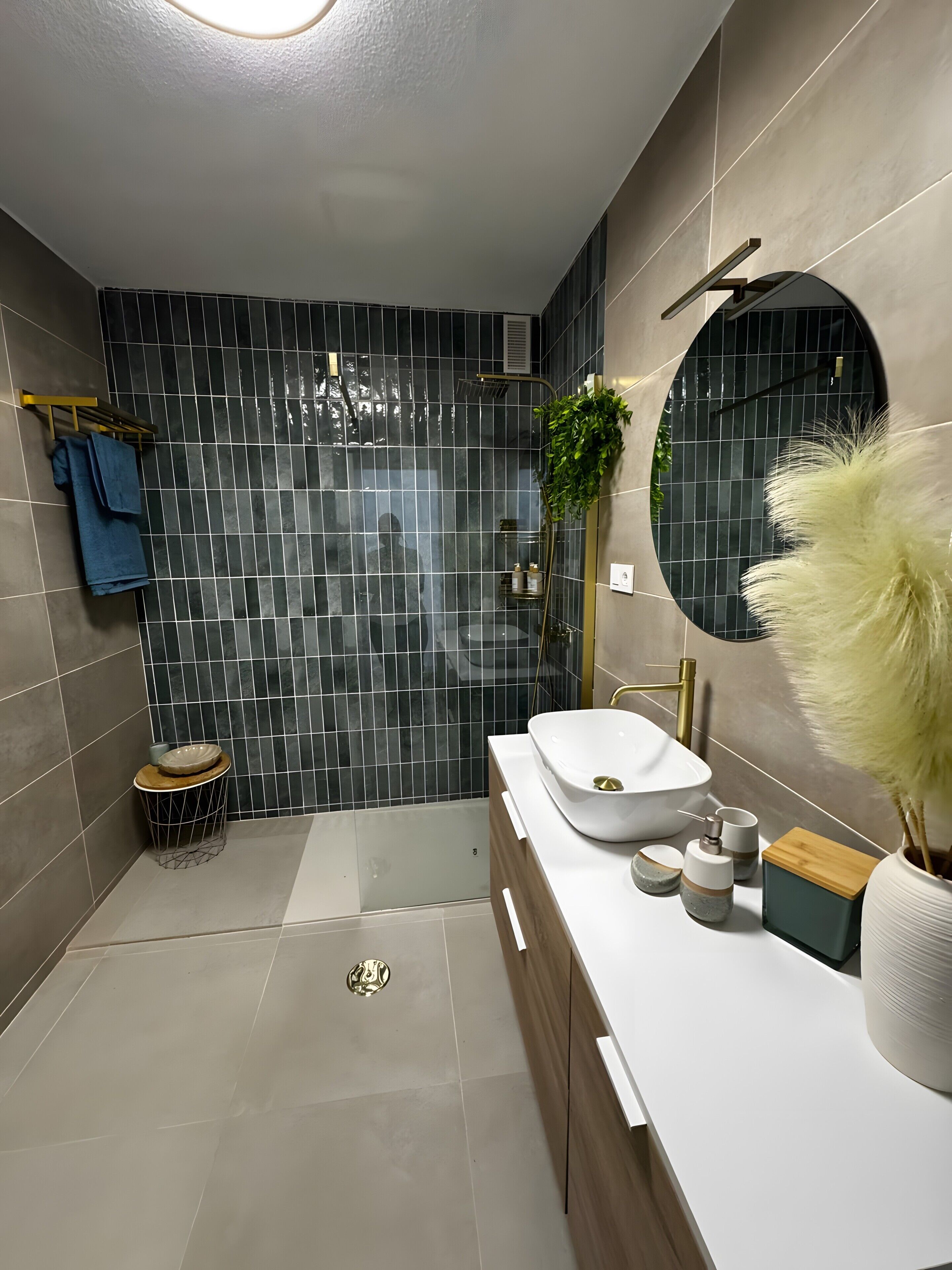 Ein modernes Badezimmer mit großem Spiegel, einem weißen Waschbecken und einer Duschkabine.