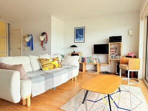 Ein modernes Wohnzimmer mit einer Couch, einem Couchtisch und einem Bücherregal.