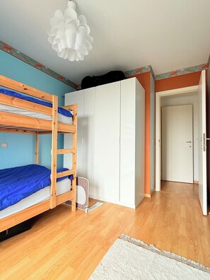 A room with a bunk bed, a wardrobe, and a door leading to another room. - Lovely Apartment for 6 Guests with Beautiful Water Views Baby Cot Included (Knokke-Heist)