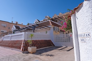 A building with a white exterior, terracotta roof tiles, and a sign reading 'TERRAZAS SOL'. - Cozy Studio Apartment in Cala Del Pino with Wi-Fi and Air Conditioning (Cartagena)