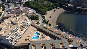 Ein Hochhotel mit Pool auf dem Dach, einem Strand und Blick auf das Meer.