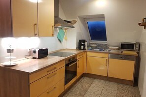 A compact kitchen with a toaster, coffee maker, microwave, and a window above the sink. - Holiday apartment with 2 bedrooms (Koserow)